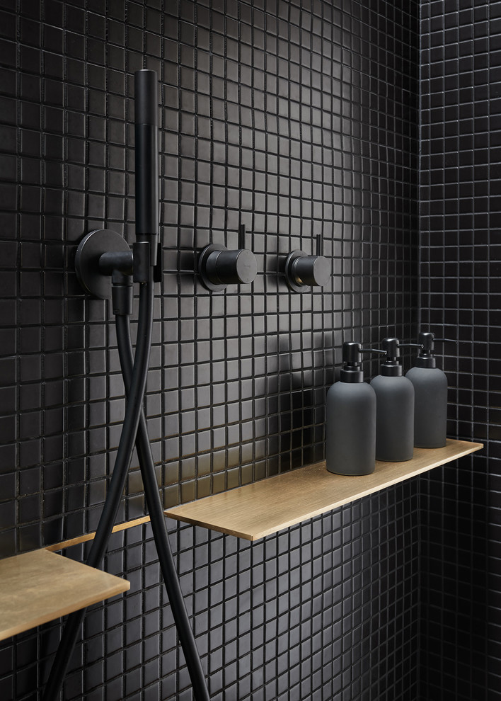 Photo of a small modern ensuite bathroom in San Francisco with flat-panel cabinets, medium wood cabinets, a double shower, a wall mounted toilet, black tiles, ceramic tiles, black walls, concrete flooring, a pedestal sink, grey floors and an open shower.