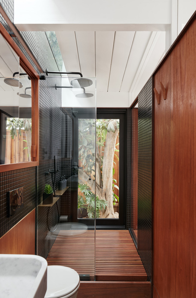 Réalisation d'une petite salle de bain principale design en bois brun avec un placard à porte plane, une douche double, WC suspendus, un carrelage noir, des carreaux de céramique, un mur noir, aucune cabine et un lavabo suspendu.
