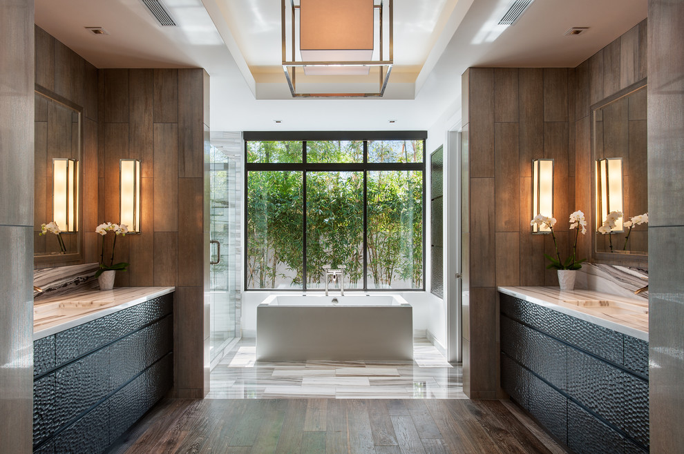 Réalisation d'une salle de bain design avec un lavabo encastré, un placard à porte plane, des portes de placard noires, une baignoire indépendante, un carrelage marron et parquet foncé.