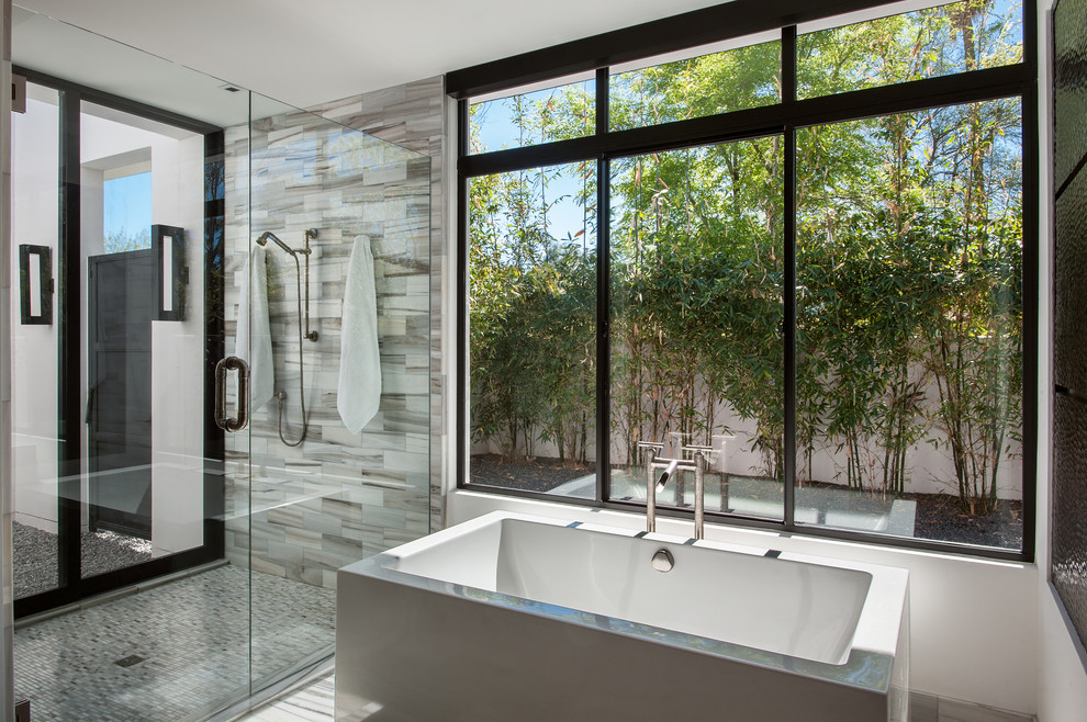 Cette photo montre une douche en alcôve principale tendance avec une baignoire indépendante, un carrelage gris, un mur blanc et une cabine de douche à porte battante.