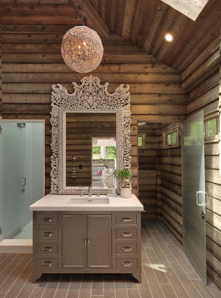 Bild på ett tropiskt vit vitt badrum, med skåp i shakerstil, grå skåp, en dusch i en alkov, ett undermonterad handfat, brunt golv och dusch med gångjärnsdörr