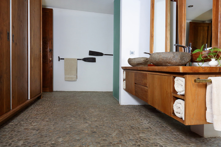 Cette photo montre une salle de bain exotique avec un carrelage beige, un mur beige et un carrelage de pierre.