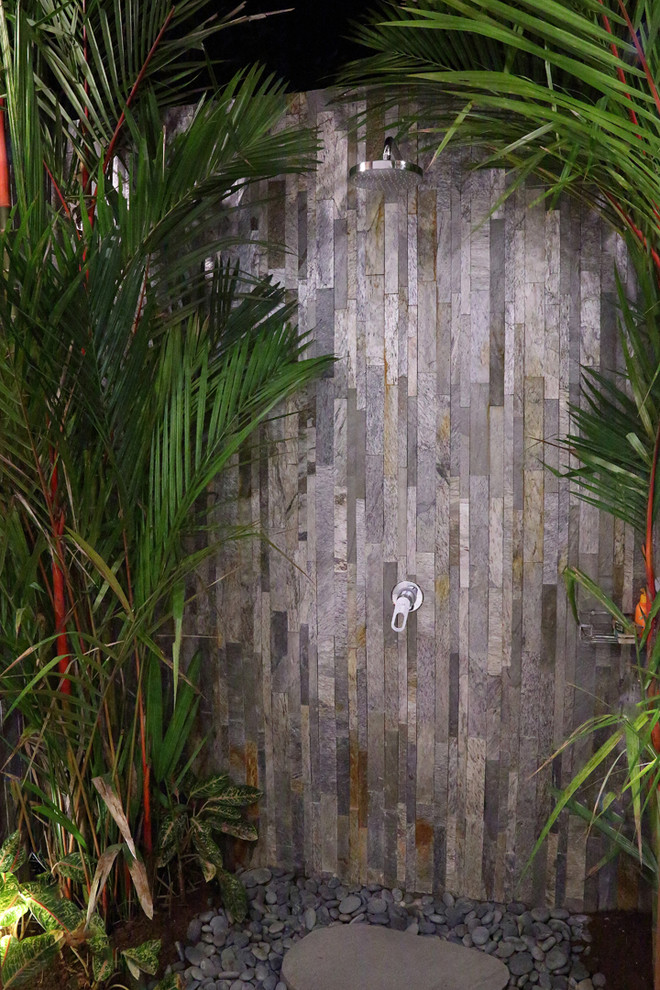 他の地域にあるトロピカルスタイルのおしゃれな浴室 (ベージュのタイル、石タイル、ベージュの壁) の写真