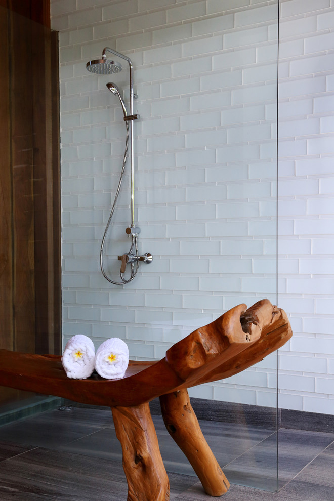 他の地域にあるトロピカルスタイルのおしゃれな浴室 (ベージュのタイル、ガラスタイル、ベージュの壁) の写真
