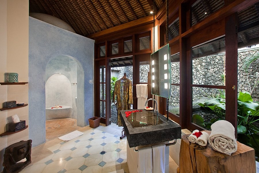 Asiatisches Badezimmer mit Duschnische, beigen Fliesen, Kalkfliesen, Kalkstein, blauem Boden und offener Dusche