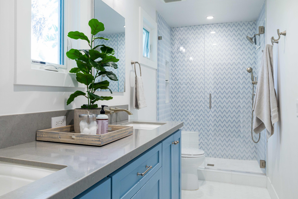 Imagen de cuarto de baño doble tradicional renovado con armarios estilo shaker, puertas de armario azules, ducha empotrada, baldosas y/o azulejos multicolor, paredes blancas, lavabo bajoencimera, suelo blanco y encimeras grises