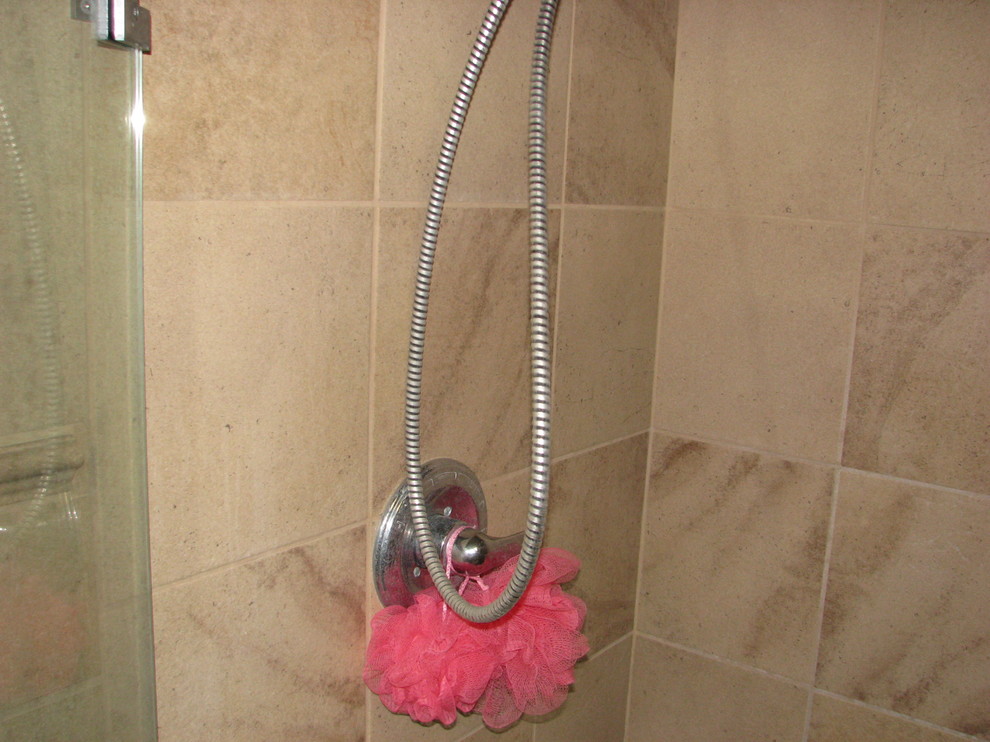 Klassisk inredning av ett litet en-suite badrum, med en dusch i en alkov, en toalettstol med separat cisternkåpa, beige kakel, keramikplattor, beige väggar, klinkergolv i keramik och ett piedestal handfat