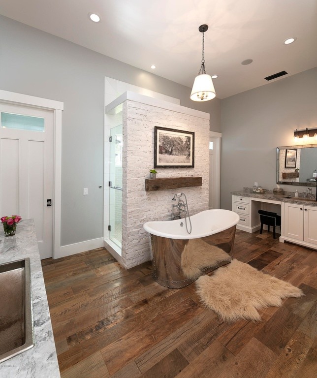 Inspiration for a large country ensuite bathroom in Orange County with recessed-panel cabinets, white cabinets, a freestanding bath, a double shower, white tiles, mosaic tiles, grey walls, medium hardwood flooring, a submerged sink, granite worktops, brown floors, a hinged door and grey worktops.