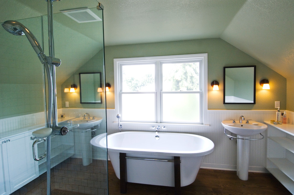 Design ideas for a large traditional ensuite bathroom in Seattle with a pedestal sink, shaker cabinets, white cabinets, wooden worktops, a freestanding bath, a corner shower, green walls and dark hardwood flooring.