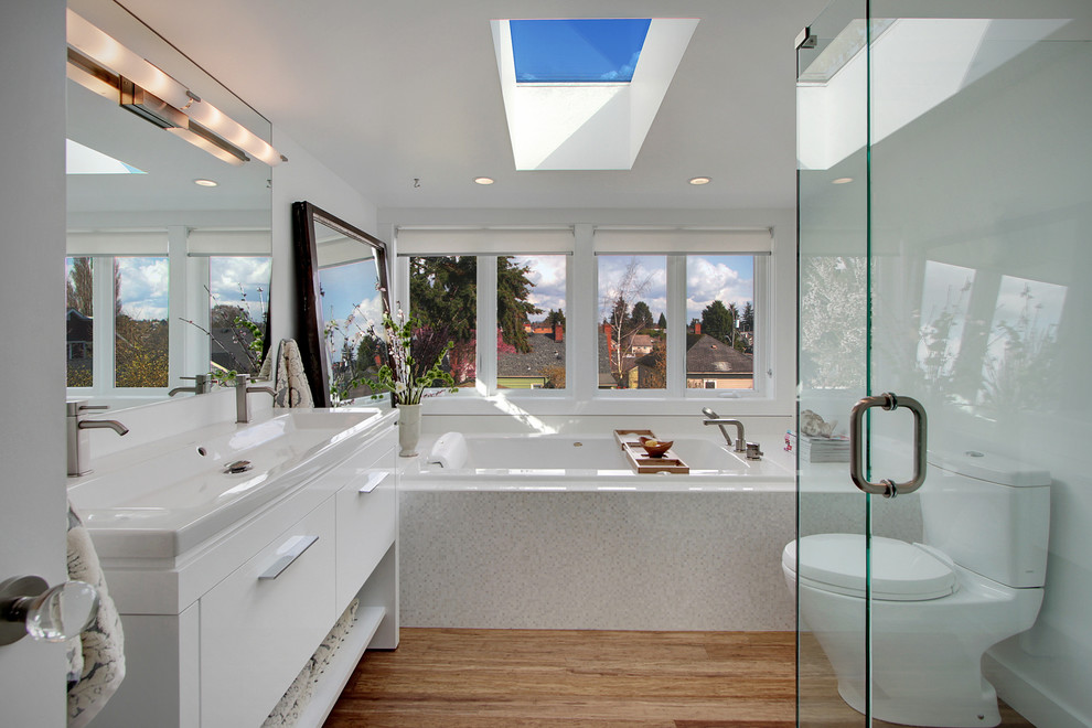 Contemporary bathroom in Seattle with a vessel sink, flat-panel cabinets, white cabinets, a built-in bath, a corner shower, a two-piece toilet and white tiles.