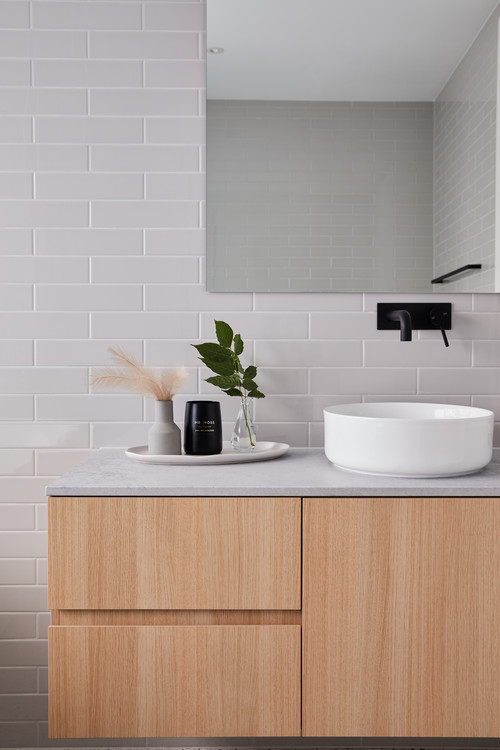 Subdued Sophistication with Gray Subway Tiles and Frameless Mirror