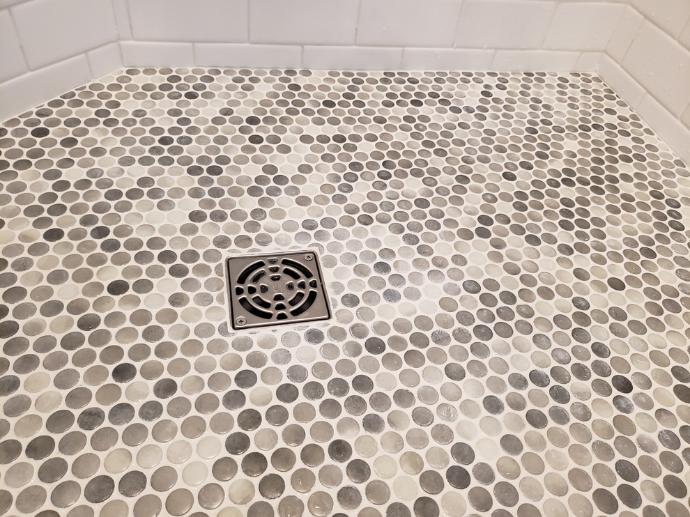 Idee per una stanza da bagno moderna con vasca ad angolo, pavimento con piastrelle di ciottoli e porta doccia a battente