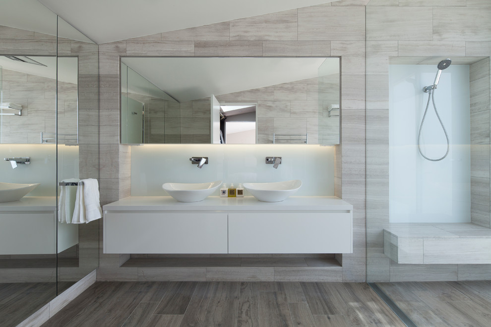 This is an example of a large modern ensuite bathroom in Sydney with a walk-in shower, flat-panel cabinets, white cabinets, grey tiles, travertine tiles, travertine flooring, a vessel sink, quartz worktops, grey floors and an open shower.