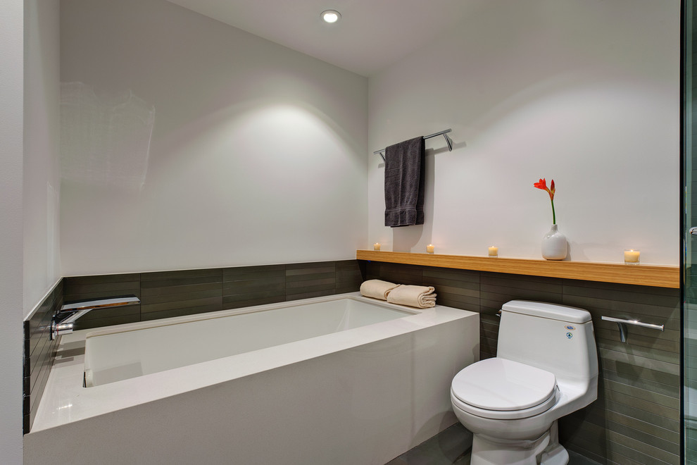 Inredning av ett modernt mellanstort badrum med dusch, med ett undermonterat badkar, en toalettstol med hel cisternkåpa, grå kakel, vita väggar och klinkergolv i porslin