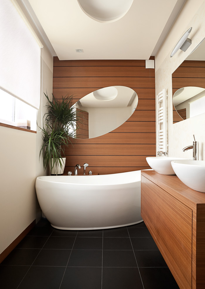 Immagine di una stanza da bagno design con lavabo a bacinella, ante lisce, ante in legno scuro, top in legno, vasca freestanding, piastrelle bianche e pareti bianche