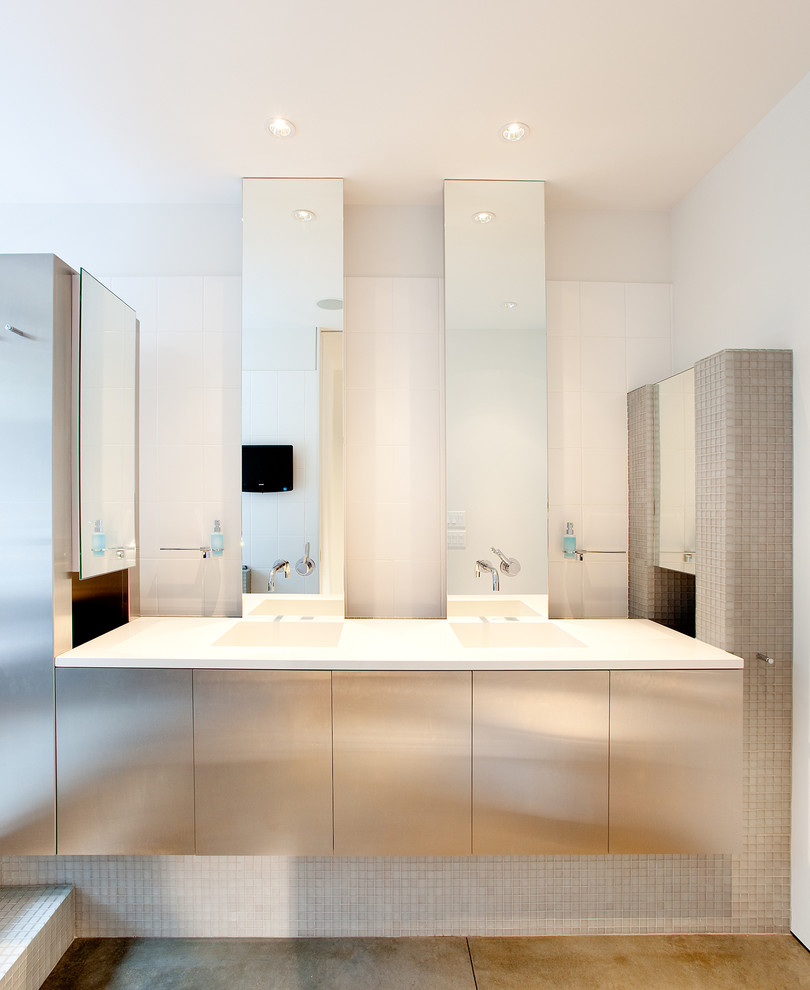 Пример оригинального дизайна: ванная комната в стиле модернизм с монолитной раковиной, плоскими фасадами, серой плиткой, плиткой мозаикой и белыми стенами