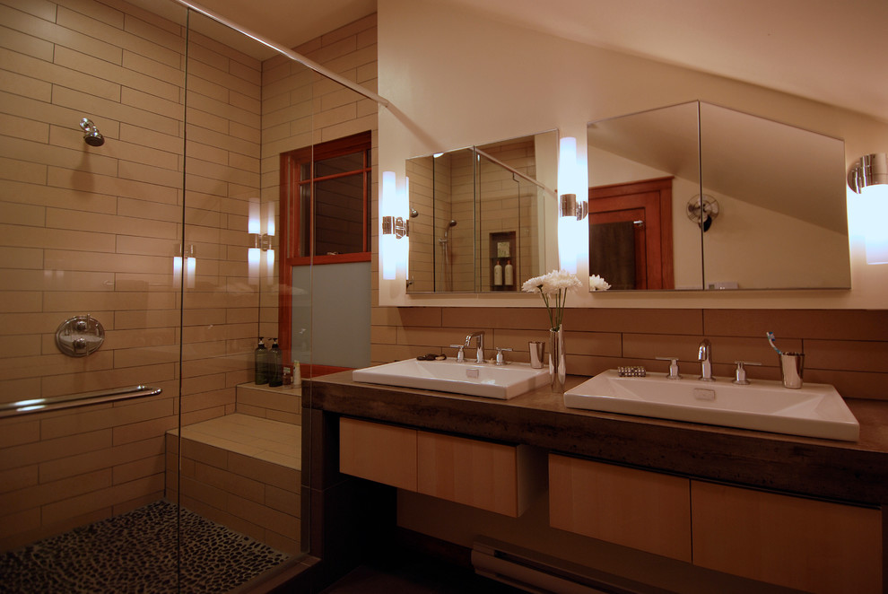 Cette image montre une grande salle de bain principale minimaliste en bois clair avec un placard à porte plane, un plan de toilette en béton, une douche double, un carrelage beige, des carreaux de porcelaine et tomettes au sol.