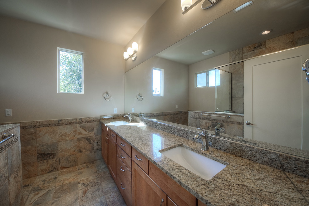 Tub/shower combo - mid-sized contemporary master beige tile and porcelain tile light wood floor tub/shower combo idea in Austin with an undermount sink, shaker cabinets, light wood cabinets, granite countertops, an undermount tub, a two-piece toilet and beige walls