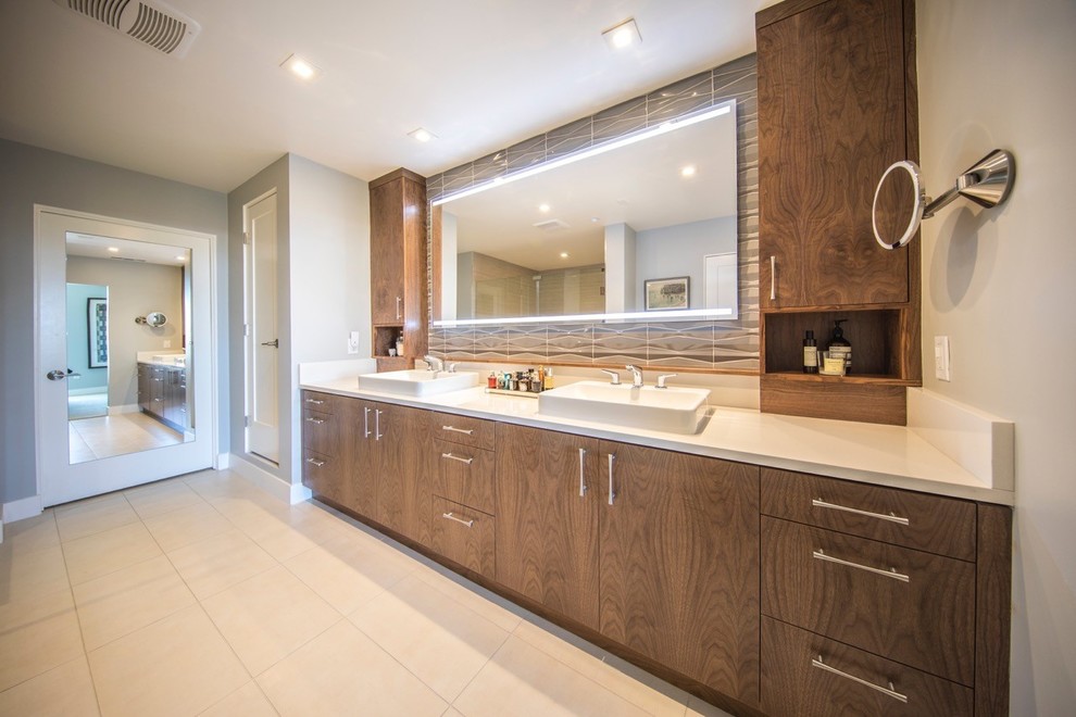 This is an example of a large contemporary ensuite bathroom in San Diego with flat-panel cabinets, medium wood cabinets, white tiles, ceramic tiles, a vessel sink, engineered stone worktops and beige worktops.