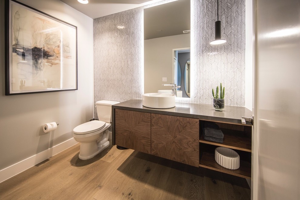 Mittelgroßes Modernes Badezimmer mit flächenbündigen Schrankfronten, hellbraunen Holzschränken, grauen Fliesen, Glasfliesen, Aufsatzwaschbecken, Quarzwerkstein-Waschtisch und grauer Waschtischplatte in San Diego