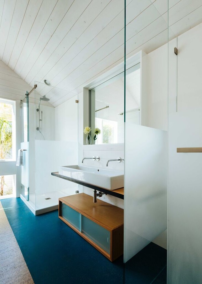 Ispirazione per una stanza da bagno con doccia contemporanea di medie dimensioni con ante di vetro, ante in legno scuro, piastrelle bianche, top in legno, pareti bianche e pavimento in cemento