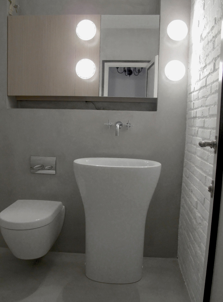 Exemple d'une salle de bain principale tendance de taille moyenne avec un placard sans porte, des portes de placard grises, WC suspendus, un carrelage gris, un mur gris, sol en béton ciré, un lavabo de ferme, un sol gris, aucune cabine et un plan de toilette blanc.