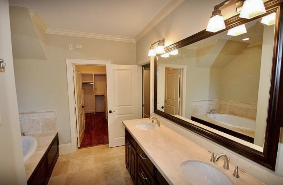 Foto di una stanza da bagno padronale tradizionale di medie dimensioni con lavabo sottopiano, ante con riquadro incassato, ante in legno bruno, top in granito, pavimento con piastrelle in ceramica e vasca da incasso