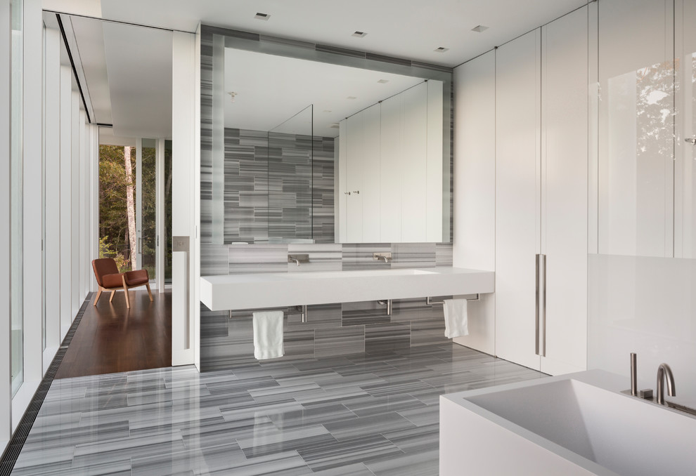 Modelo de cuarto de baño principal moderno grande con paredes blancas, suelo de azulejos de cemento, lavabo de seno grande y suelo gris