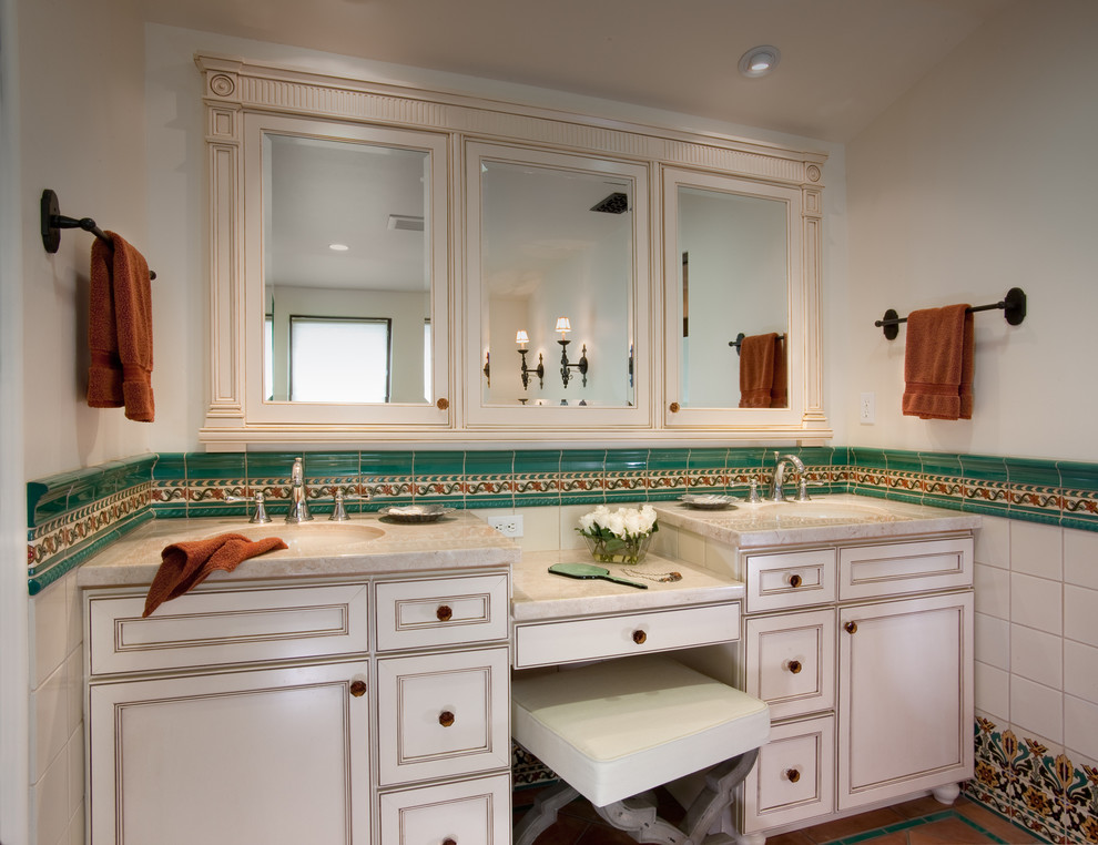На фото: ванная комната в средиземноморском стиле с врезной раковиной, фасадами с выступающей филенкой, белыми фасадами, мраморной столешницей, разноцветной плиткой, керамической плиткой, белыми стенами и полом из терракотовой плитки
