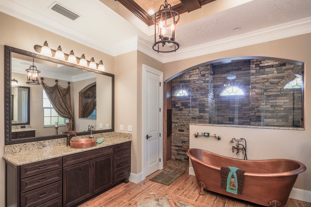 Diseño de cuarto de baño de estilo americano con puertas de armario de madera oscura, aseo y ducha y encimera de granito