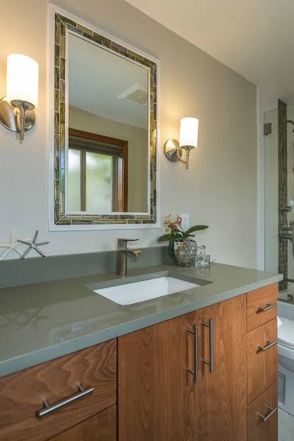 Exemple d'une salle de bain principale exotique en bois brun de taille moyenne avec un placard à porte plane, une baignoire en alcôve, un combiné douche/baignoire, WC à poser, un carrelage vert, un carrelage de pierre, un mur beige, un sol en carrelage de porcelaine et un lavabo encastré.