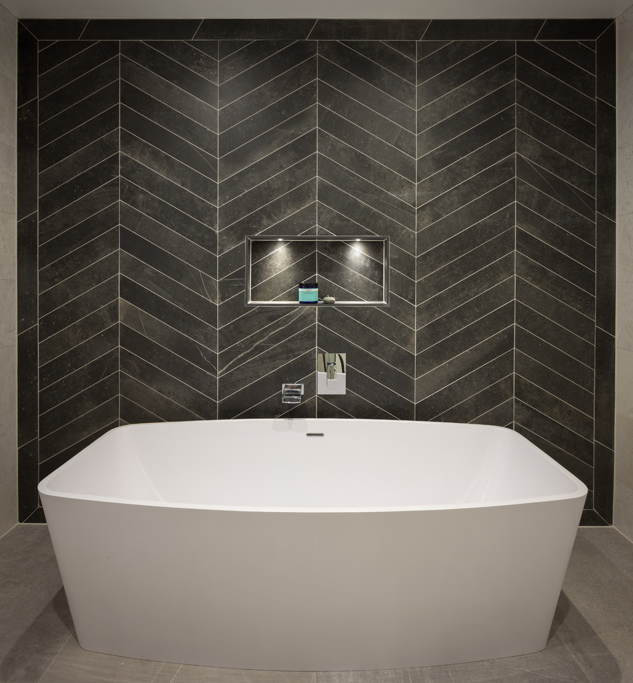 Immagine di una stanza da bagno per bambini minimalista con vasca freestanding, pistrelle in bianco e nero, pavimento in gres porcellanato e pavimento grigio