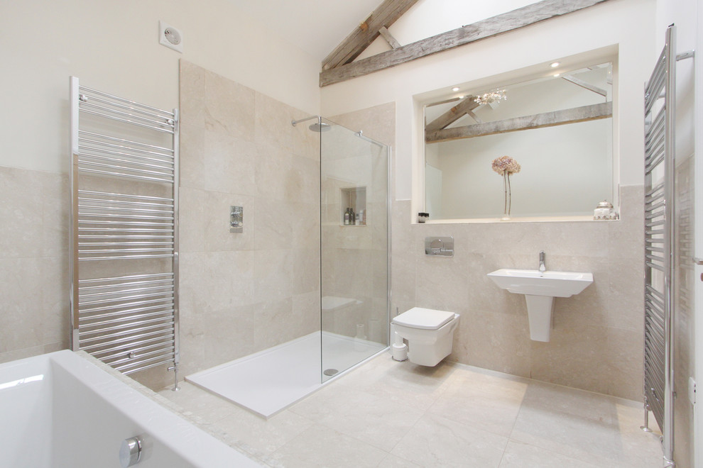 Cette image montre une salle de bain design avec un lavabo suspendu, une baignoire posée, une douche d'angle, WC suspendus, un carrelage beige et un mur beige.