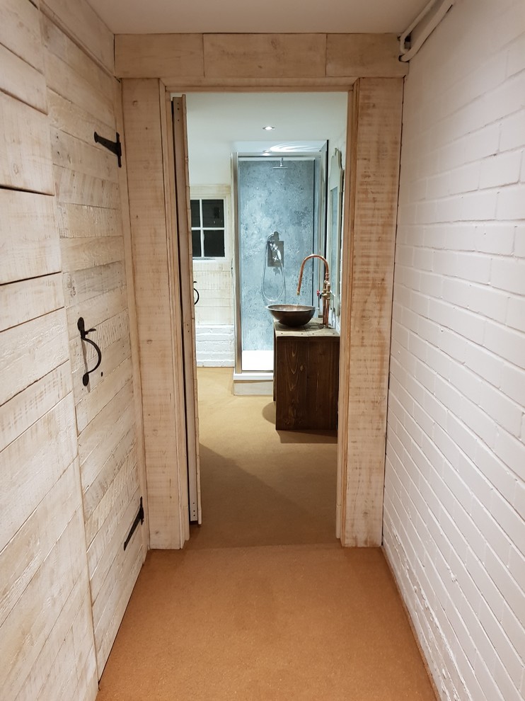 Cette image montre une salle de bain chalet avec un sol marron.