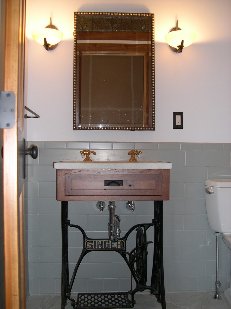 Modelo de cuarto de baño campestre de tamaño medio con puertas de armario de madera oscura, baldosas y/o azulejos multicolor, paredes blancas, aseo y ducha y lavabo encastrado
