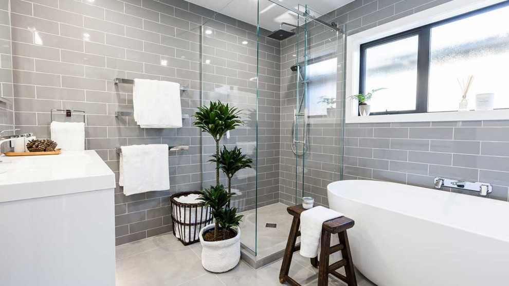 Large rustic family bathroom in London with flat-panel cabinets, white cabinets, a freestanding bath, a corner shower, a two-piece toilet, grey tiles, ceramic tiles, grey walls, porcelain flooring, an integrated sink, solid surface worktops, grey floors, a sliding door, white worktops, a single sink and a floating vanity unit.