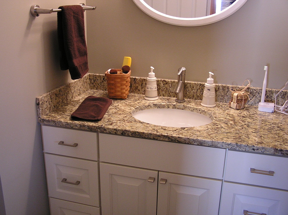 Example of a gray tile and porcelain tile walk-in shower design in Minneapolis with an undermount sink, raised-panel cabinets, white cabinets, granite countertops and a two-piece toilet