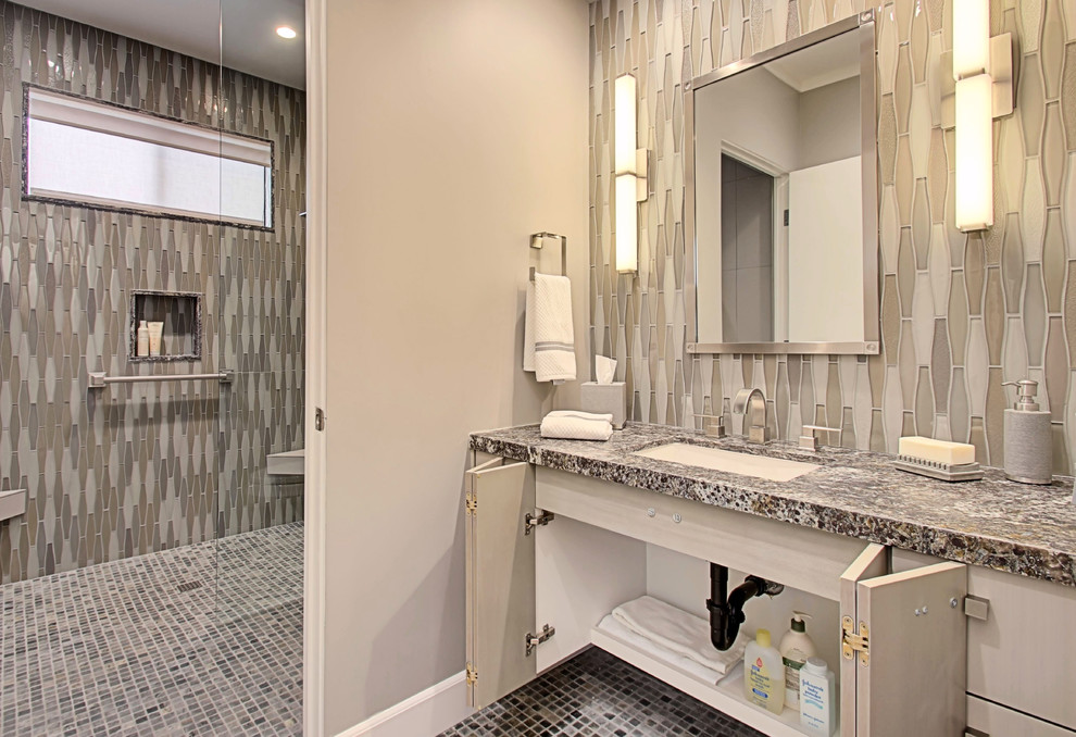 Modern inredning av ett stort badrum med dusch, med släta luckor, skåp i ljust trä, en kantlös dusch, en toalettstol med hel cisternkåpa, flerfärgad kakel, mosaik, grå väggar, skiffergolv, ett undermonterad handfat och granitbänkskiva