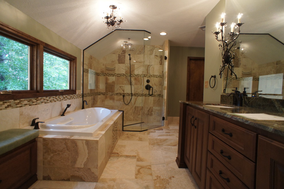 Photo of a large ensuite bathroom in Kansas City with recessed-panel cabinets, dark wood cabinets, a built-in bath, a corner shower, multi-coloured tiles, matchstick tiles, green walls, travertine flooring, a submerged sink and marble worktops.