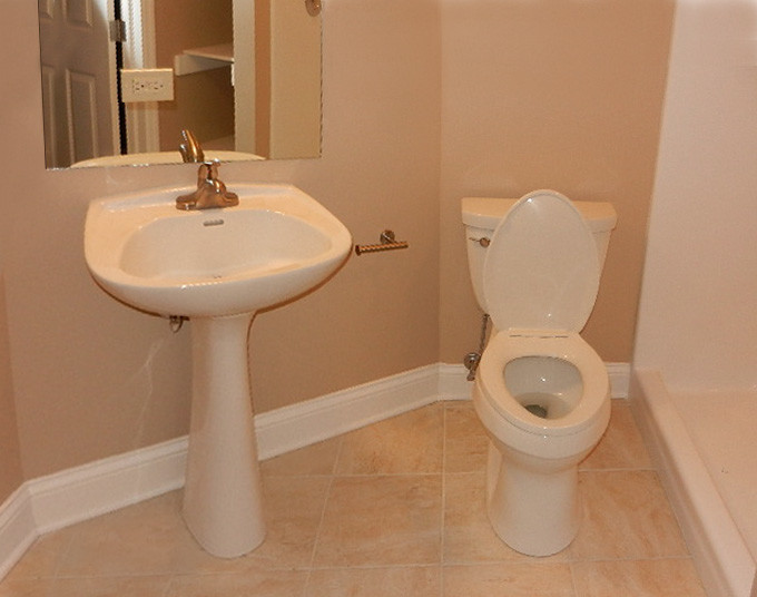 This is an example of a small traditional shower room bathroom in Chicago with a pedestal sink, a one-piece toilet, beige tiles, stone tiles, beige walls and ceramic flooring.