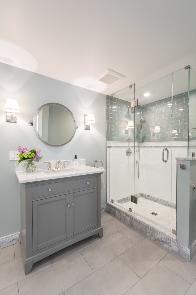 Стильный дизайн: главная ванная комната среднего размера в стиле неоклассика (современная классика) с фасадами в стиле шейкер, серыми фасадами, душем в нише, унитазом-моноблоком, зеленой плиткой, стеклянной плиткой, зелеными стенами, полом из керамогранита, врезной раковиной, мраморной столешницей, серым полом, душем с распашными дверями и белой столешницей - последний тренд
