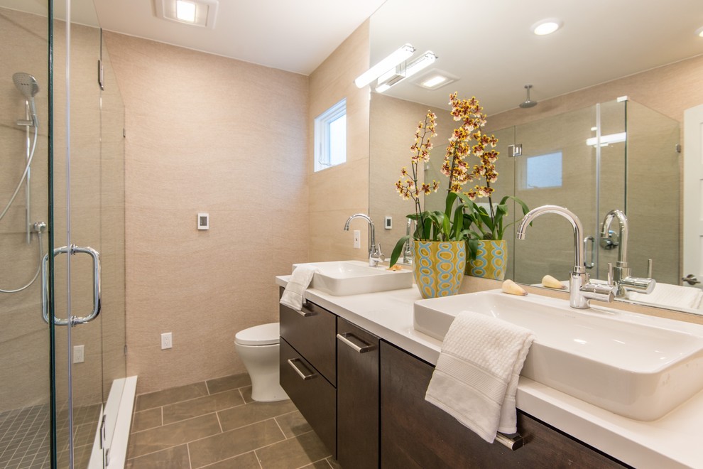 Foto di una stanza da bagno minimal con ante lisce, ante in legno bruno e piastrelle grigie