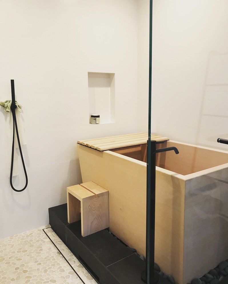Photo of a medium sized world-inspired ensuite wet room bathroom in San Francisco with flat-panel cabinets, dark wood cabinets, white tiles, concrete worktops, white worktops, a japanese bath, a one-piece toilet, white walls, pebble tile flooring, an integrated sink, beige floors and an open shower.