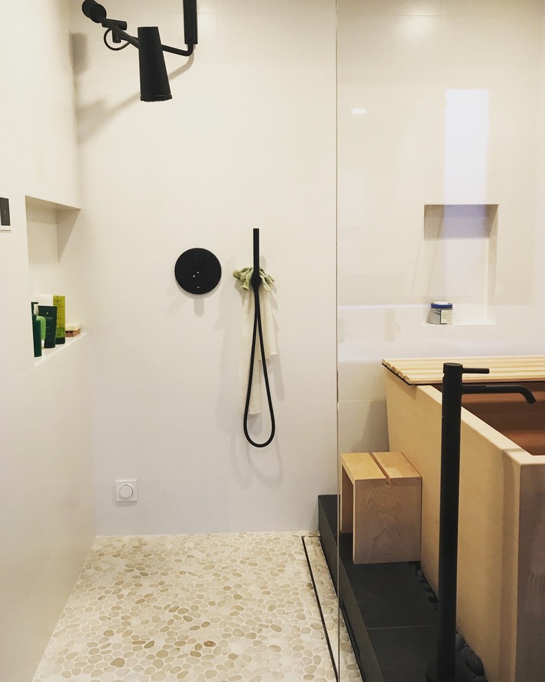 На фото: ванная комната в восточном стиле с японской ванной, душевой комнатой, унитазом-моноблоком, белой плиткой, белыми стенами, полом из галечной плитки, монолитной раковиной, столешницей из бетона, бежевым полом, открытым душем и белой столешницей