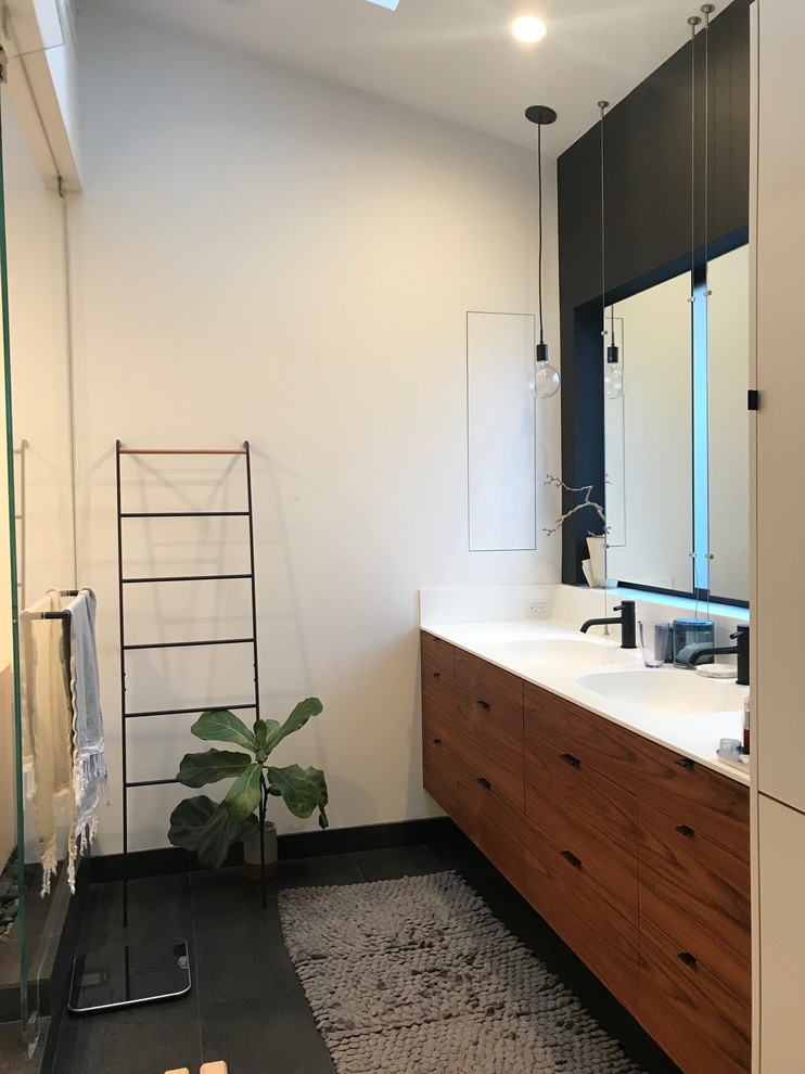 Inspiration for a mid-sized asian master white tile pebble tile floor and beige floor bathroom remodel in San Francisco with flat-panel cabinets, dark wood cabinets, a one-piece toilet, white walls, an integrated sink, concrete countertops and white countertops