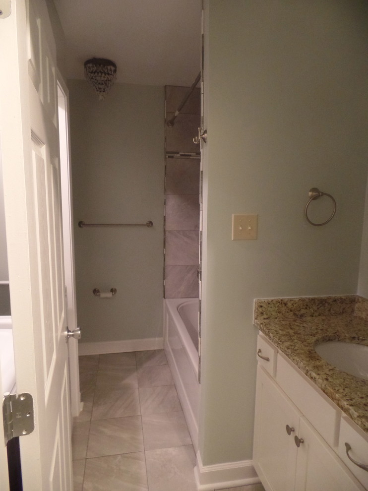 Inredning av ett klassiskt mellanstort badrum för barn, med ett undermonterad handfat, skåp i shakerstil, vita skåp, granitbänkskiva, ett badkar i en alkov, en dusch i en alkov, en toalettstol med separat cisternkåpa, grå kakel, porslinskakel, gröna väggar och klinkergolv i porslin