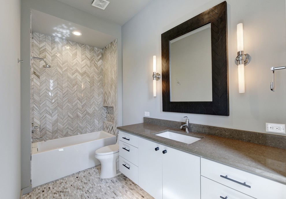 Inspiration för stora klassiska vitt badrum för barn, med vita skåp, ett badkar i en alkov, en dusch/badkar-kombination, en toalettstol med hel cisternkåpa, flerfärgad kakel, stenkakel, grå väggar, mosaikgolv, ett undermonterad handfat, bänkskiva i akrylsten och flerfärgat golv