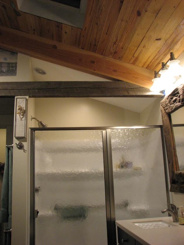 Inspiration pour une salle de bain craftsman en bois foncé de taille moyenne avec un placard avec porte à panneau encastré, une baignoire posée, un mur beige, un lavabo encastré, un plan de toilette en surface solide et une cabine de douche à porte battante.