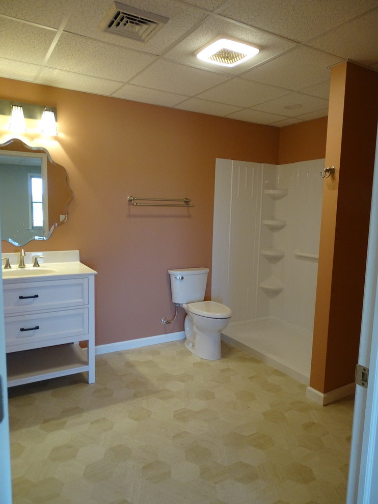 Стильный дизайн: большая ванная комната в классическом стиле с фасадами островного типа, белыми фасадами, душем в нише, раздельным унитазом, розовой плиткой, полом из винила, монолитной раковиной, столешницей из искусственного кварца, открытым душем, белой столешницей, душевой кабиной, бежевым полом и оранжевыми стенами - последний тренд