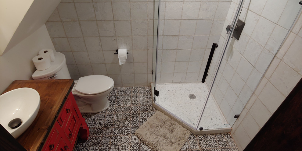 Bild på ett mellanstort vintage brun brunt badrum med dusch, med möbel-liknande, en toalettstol med separat cisternkåpa, keramikplattor, vita väggar, klinkergolv i keramik, ett fristående handfat, träbänkskiva, röda skåp, en hörndusch, vit kakel, svart golv och dusch med gångjärnsdörr